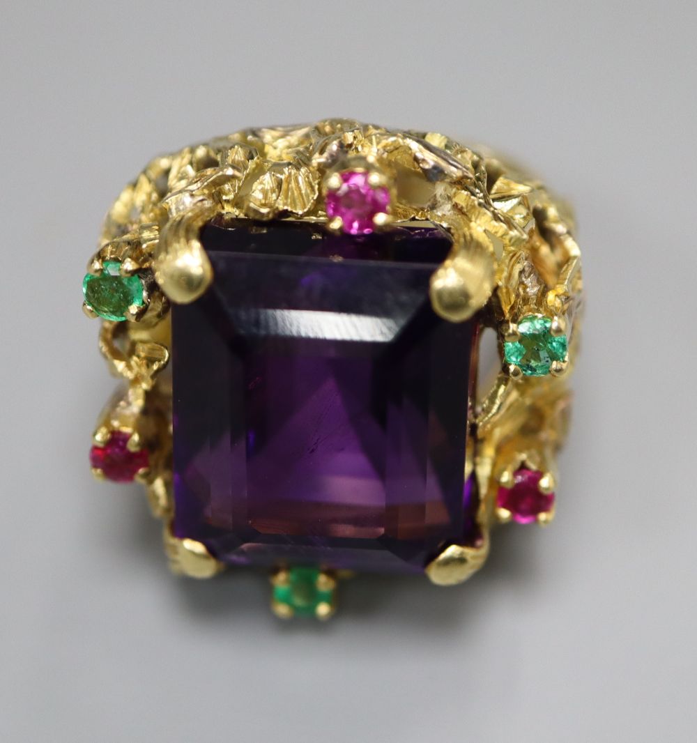 A yellow metal, amethyst, emerald and ruby cluster set naturalistic dress ring, size M, gross 20.9 grams.